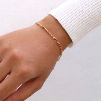 woman wearing the gold figaro bracelet