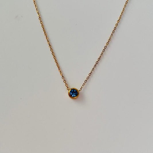 gold necklace with blue december birthstone