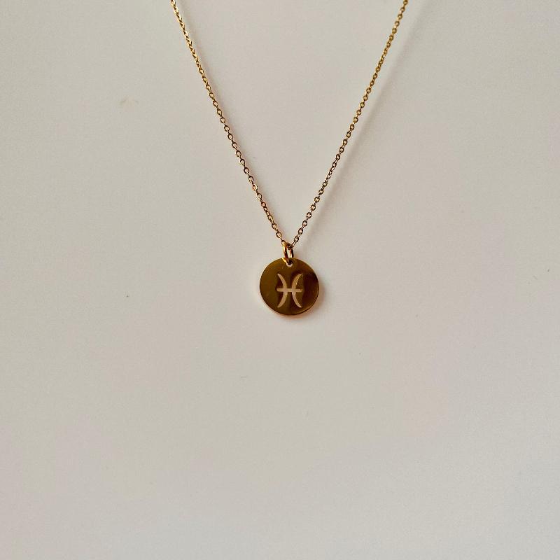 Pisces symbol on a gold disc and on a chain necklace