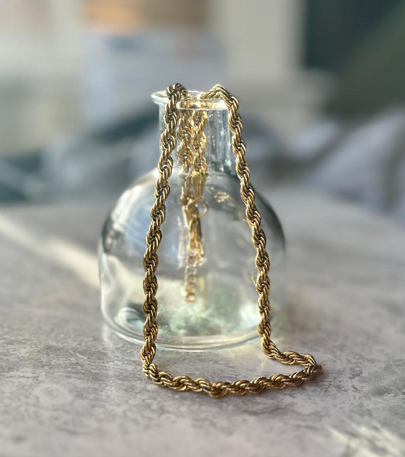 rope chain necklace over a glass bottle