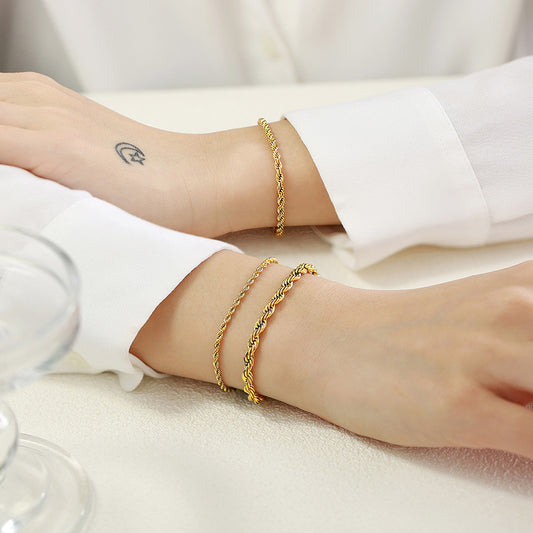 a woman wearing gold rope bracelets in different widths